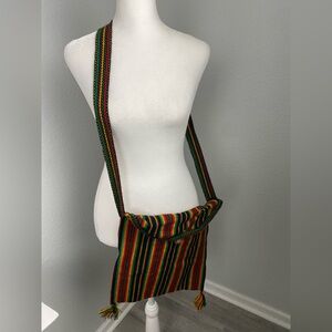 Colorful crossbody bag featuring a striped pattern with bohemian fringed tassels